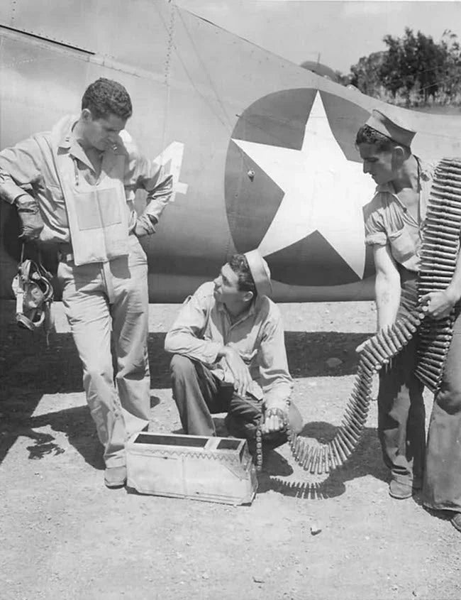 Capt. Joseph Jacob Foss, World War II Ace, watching two navy armorers loading amo into his F4F wildcat.