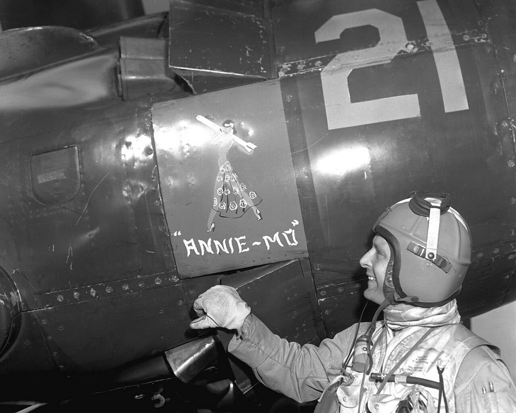 Lt. Guy Bordelon looking at the name plate Annie-Mo on his Vought F4U-5N Corsair fighter