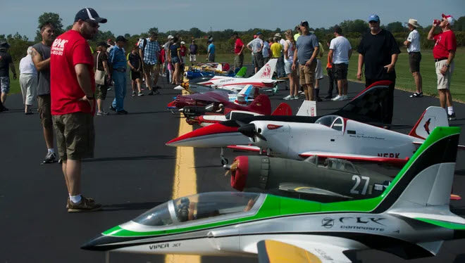 Radio Control Flying Club with spectators and RC airplanes displayed.