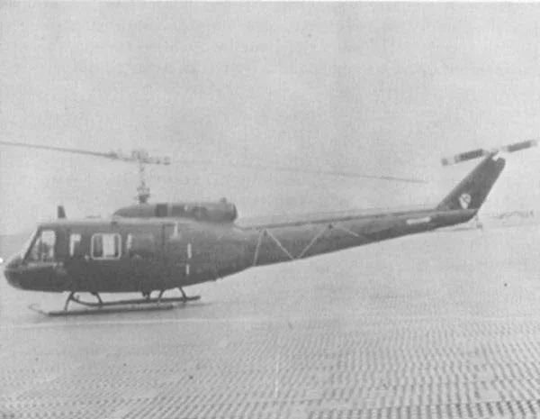 A photograph of a UH-1 helicopter on a landing pad in Vietnam