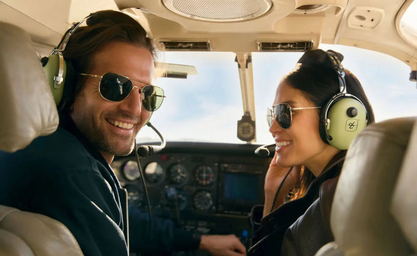 A pilot wearing a pair of AO Original PIlots Gold sunglasses and a passenger wearing a pair of AO General Pilot Gold sunglasses.