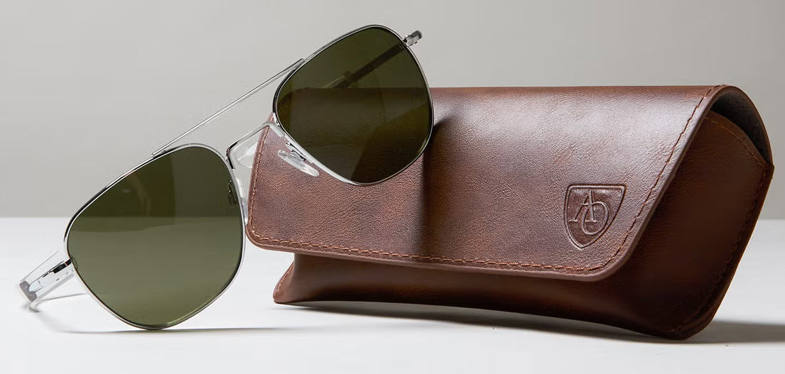 A photograph of a pair of Silver frame AO Original Pilot Sunglasses with Green Glass Lenses and the leather AO Carying Case