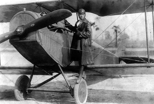 A photo of Bessie Coleman standing on the wing of her Jenny in 1922