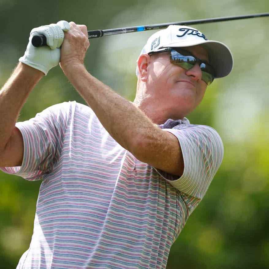 Steve Flesch preparing to swing and hit his golf ball wearing a pair of Scheyden CIA Grabber sunglasses for comfort and visual acuity.