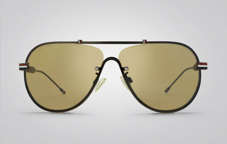 A pair of Eagle Eyes Hero aviator sunglasses with a red-white-blue metal temples and a black frame and warm yellow-tinted lenses.